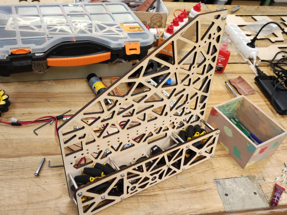 Drivetrain side assembly mid-build — laser-cut plywood plate with motors and mecanum wheels fitted